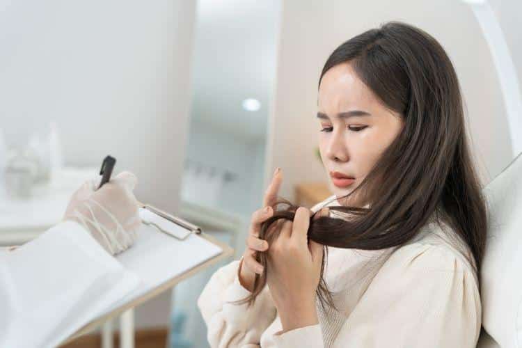 Woman looking at hair in specialist appointment