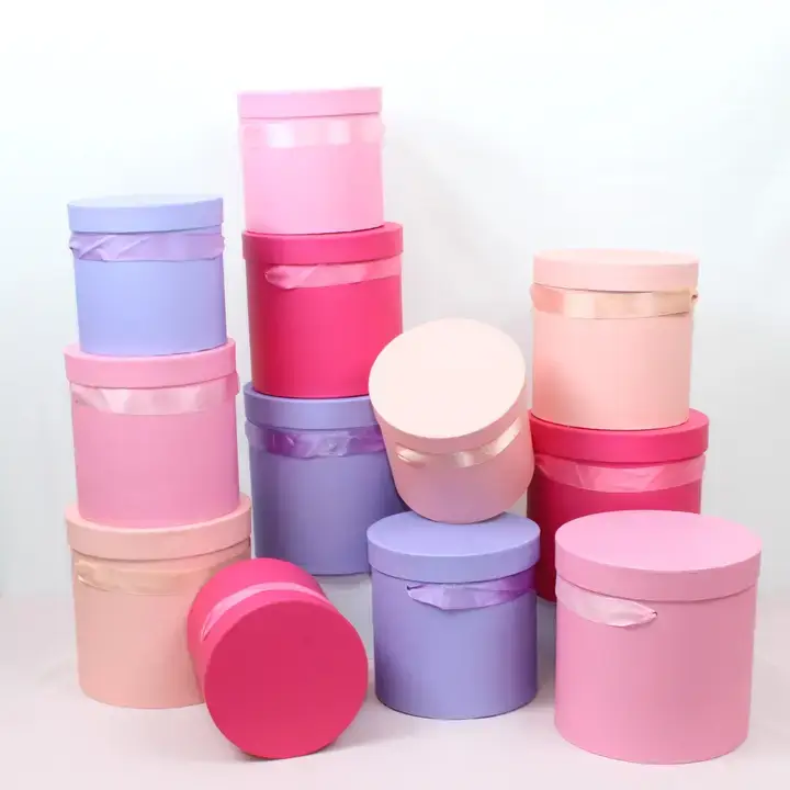 Assorted pink and purple hat boxes stacked against a white background