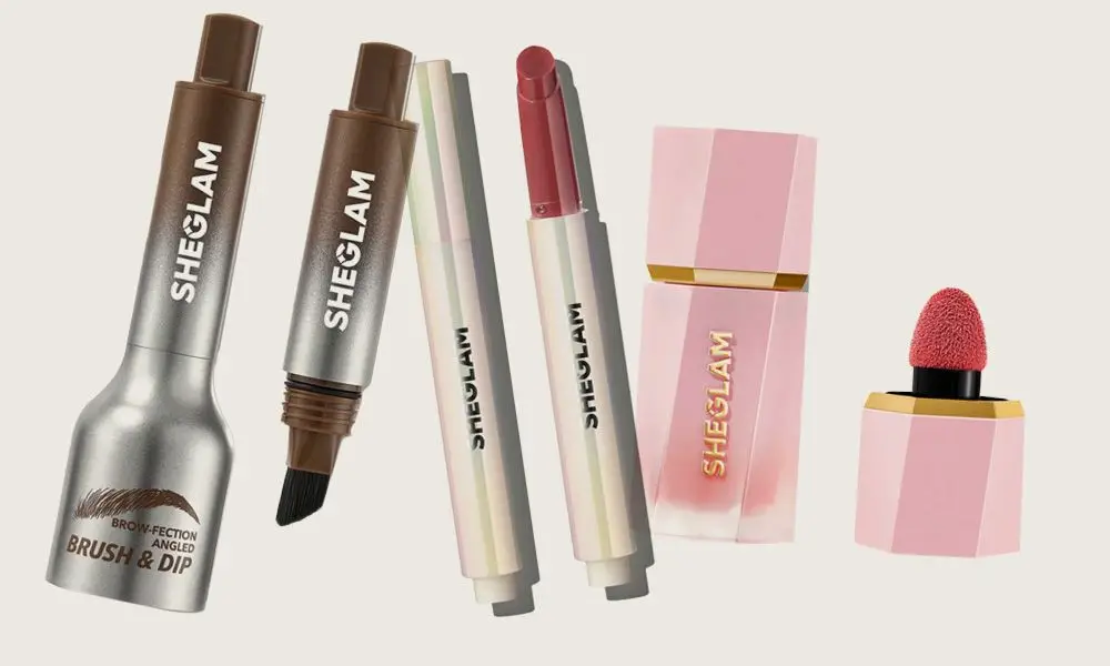 Makeup products collection including lipsticks and brow brushes with pink and gold packaging