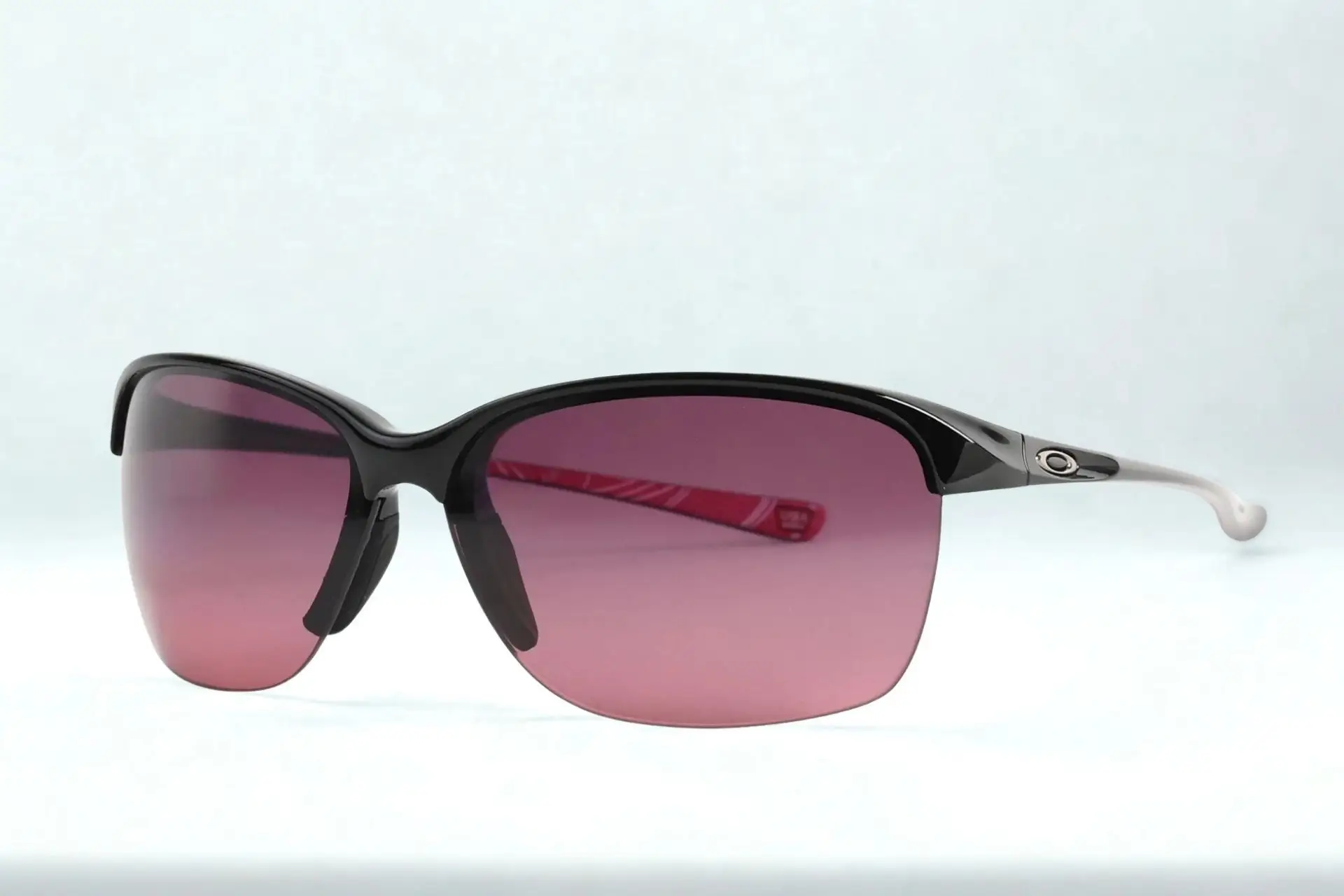Black-framed sunglasses with red-tinted lenses in a bright setting