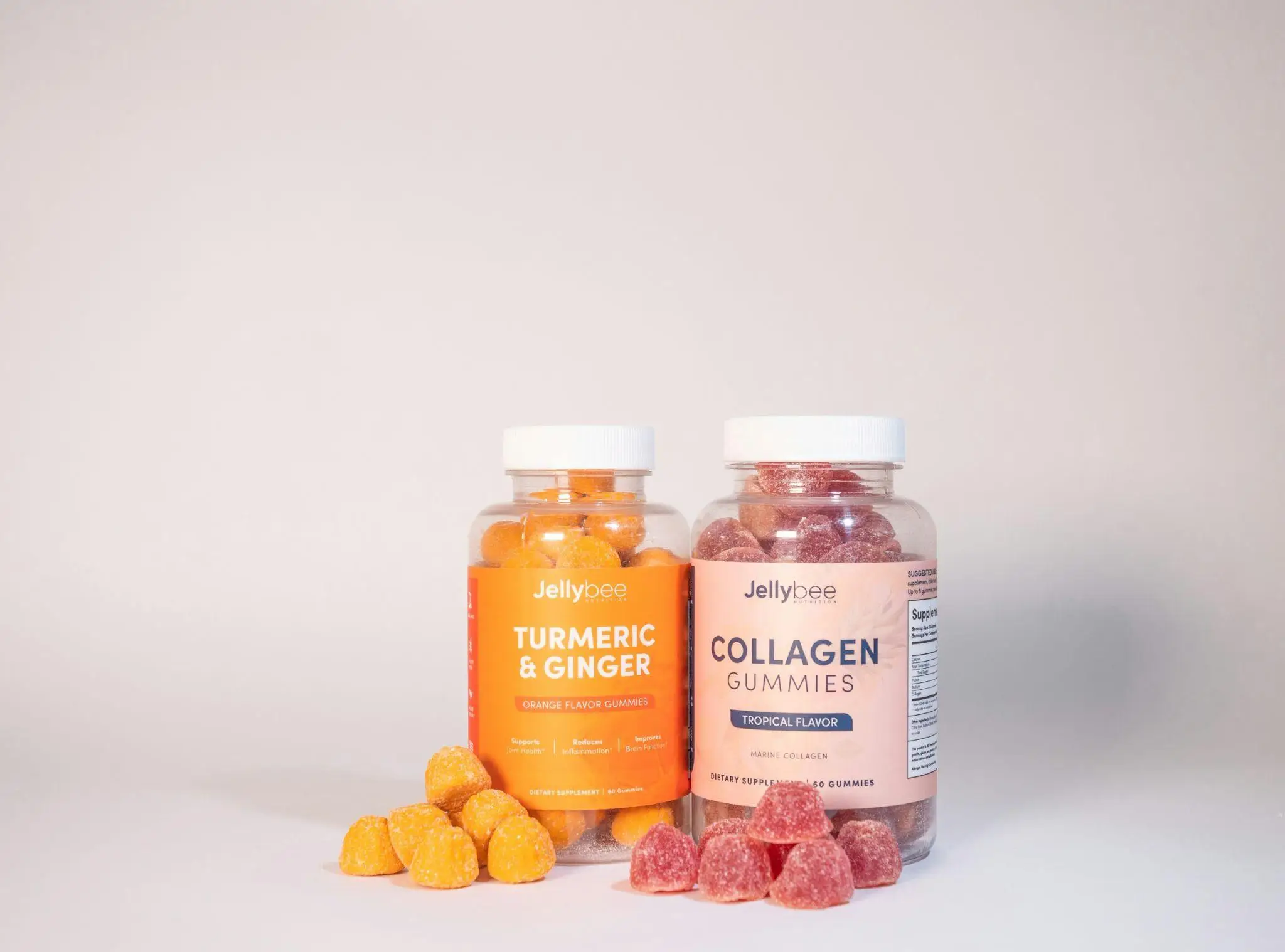 Turmeric and ginger, collagen gummies in clear jars on neutral background