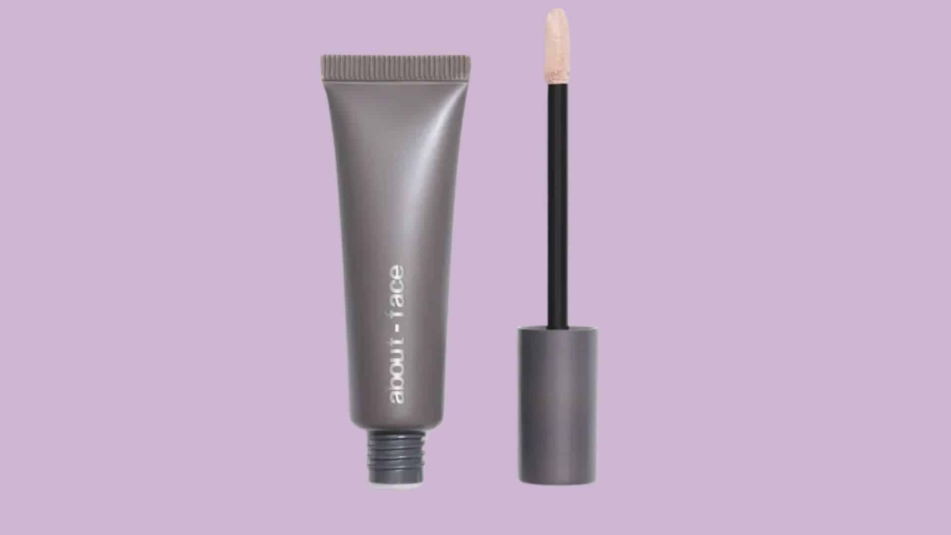 About Face Smoothing Shadow Fix eyeshadow primer tube with applicator on a purple background