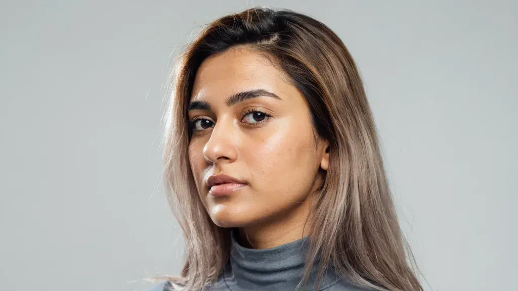 Medium length ash brown hair with subtle blonde highlights styled in a sleek straight layered cut with smooth texture and shine