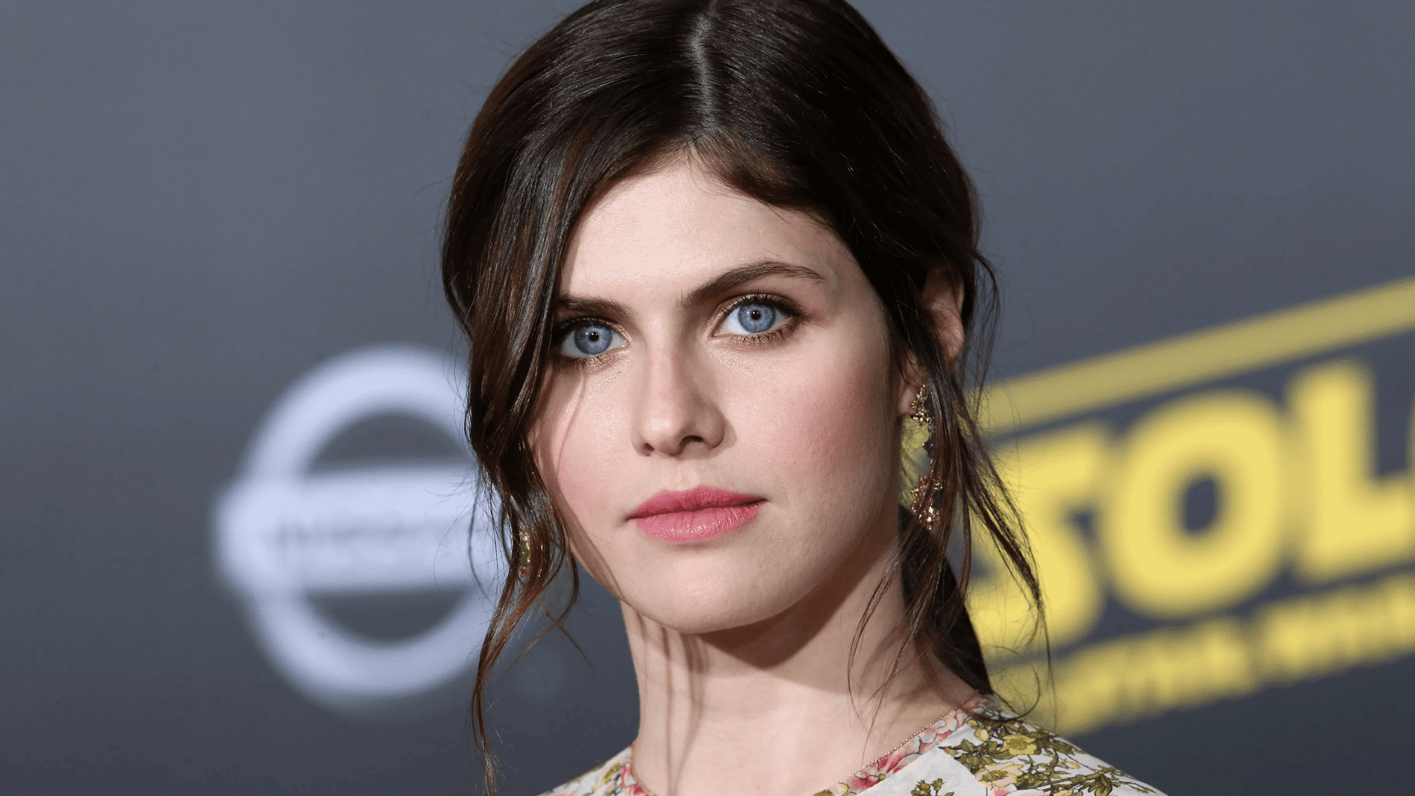 Woman with dark black hair and striking blue eyes in a portrait
