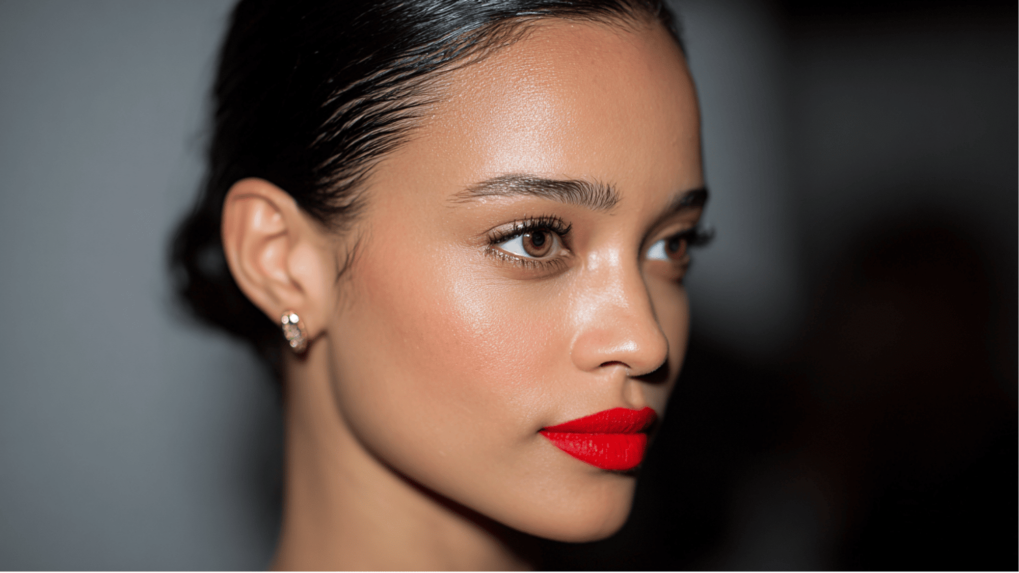 Bold lip makeup style with vibrant red lipstick, defined eyes, and a statement beauty finish