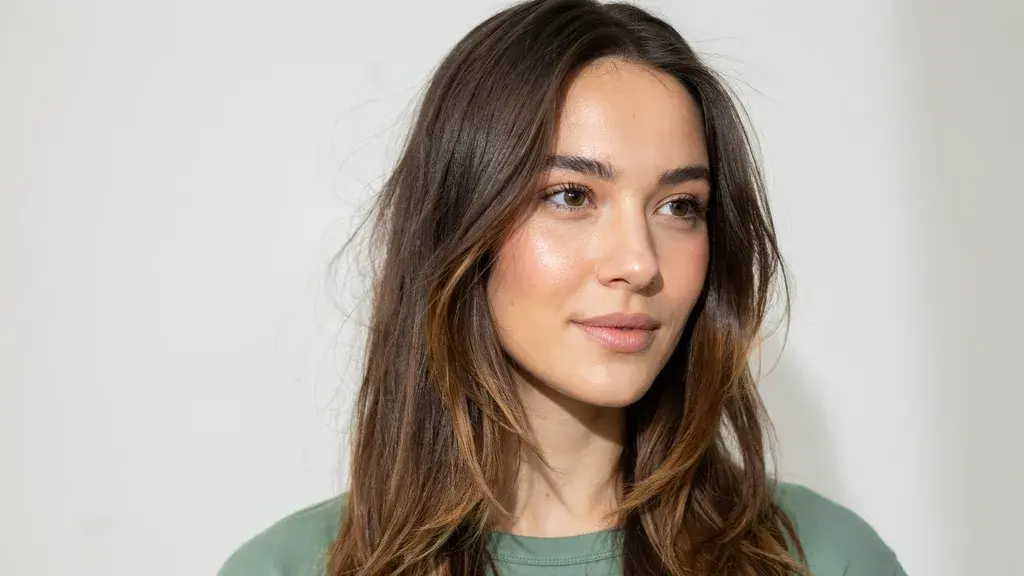 Dark brown hair with subtle caramel highlights styled in soft layers with a smooth natural texture and volume