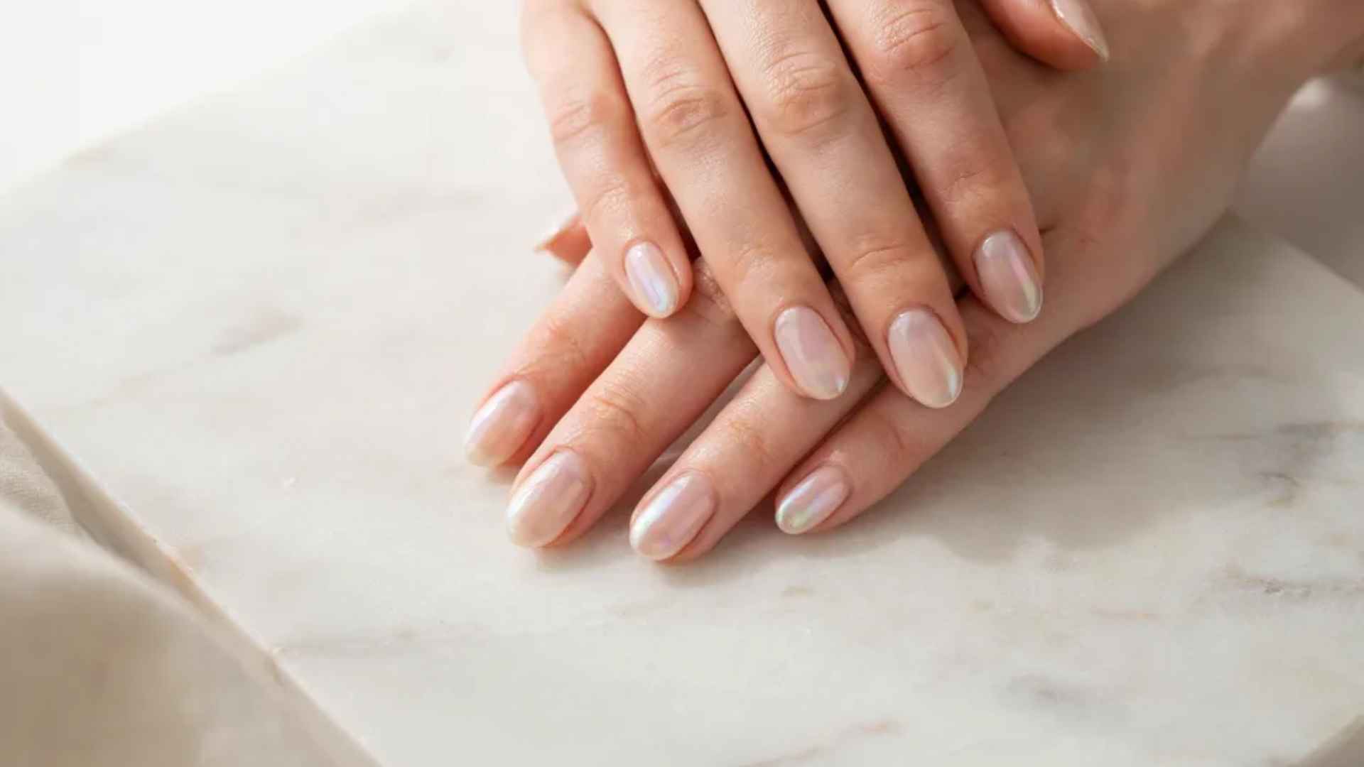 Classic milky chrome glazed donut nails with a sheer white base and soft pearly shine on elegant almond shaped nails