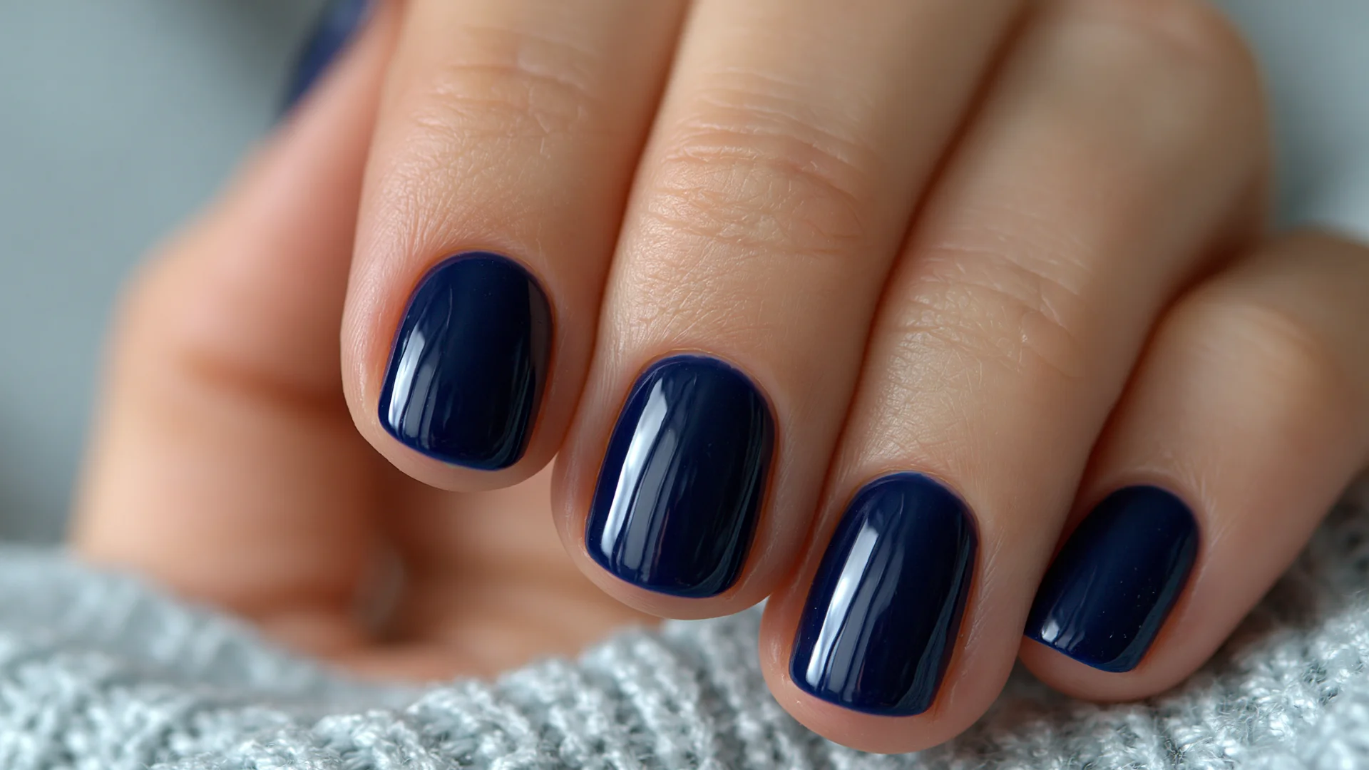 Minimal dark blue nail art featuring polished nails with a sleek shine and sophisticated rounded nail shape