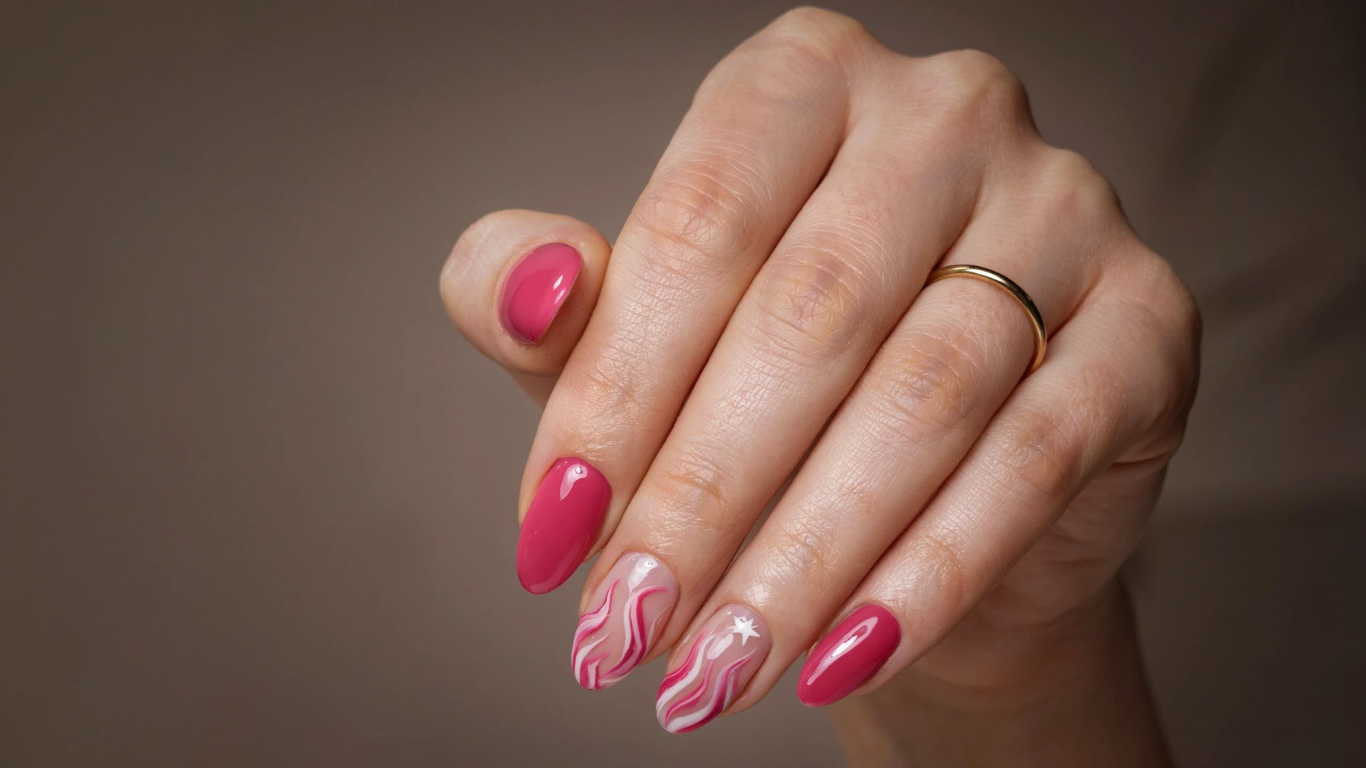 Stylish pink nail design with wavy white patterns and tiny star accents creating a playful glossy manicure look