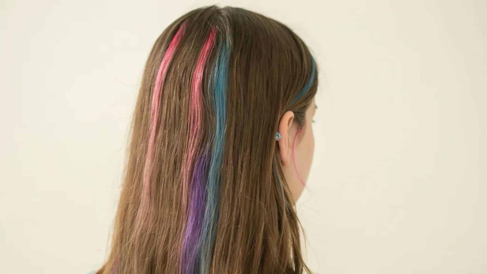 Early 2000s hairstyle with bold pink, blue, and purple colored hair streaks.