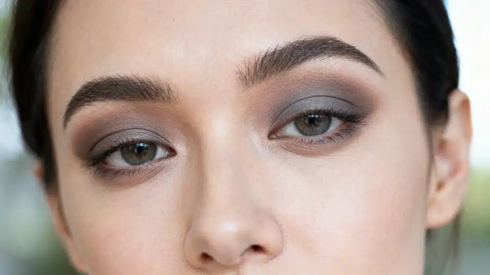 Woman wearing cool taupe eyeshadow softly blended across the eyelids for a neutral everyday look.
