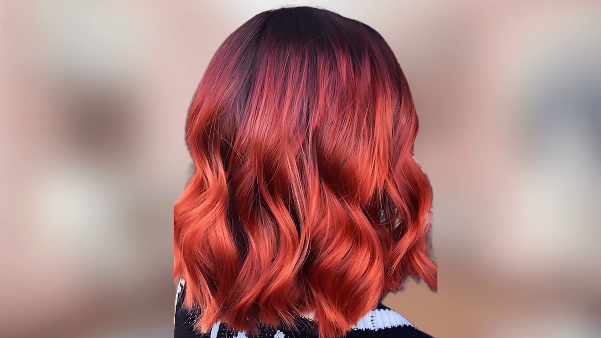 Shoulder length wavy hair showing coral red shade with vibrant orange red tones