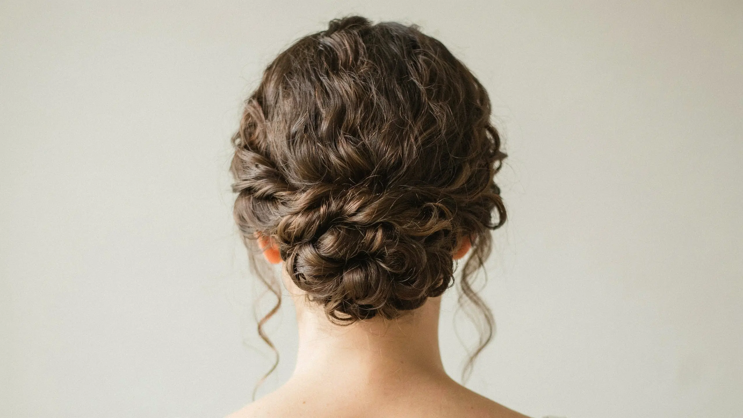 Curly hair styled into a textured updo hairstyle