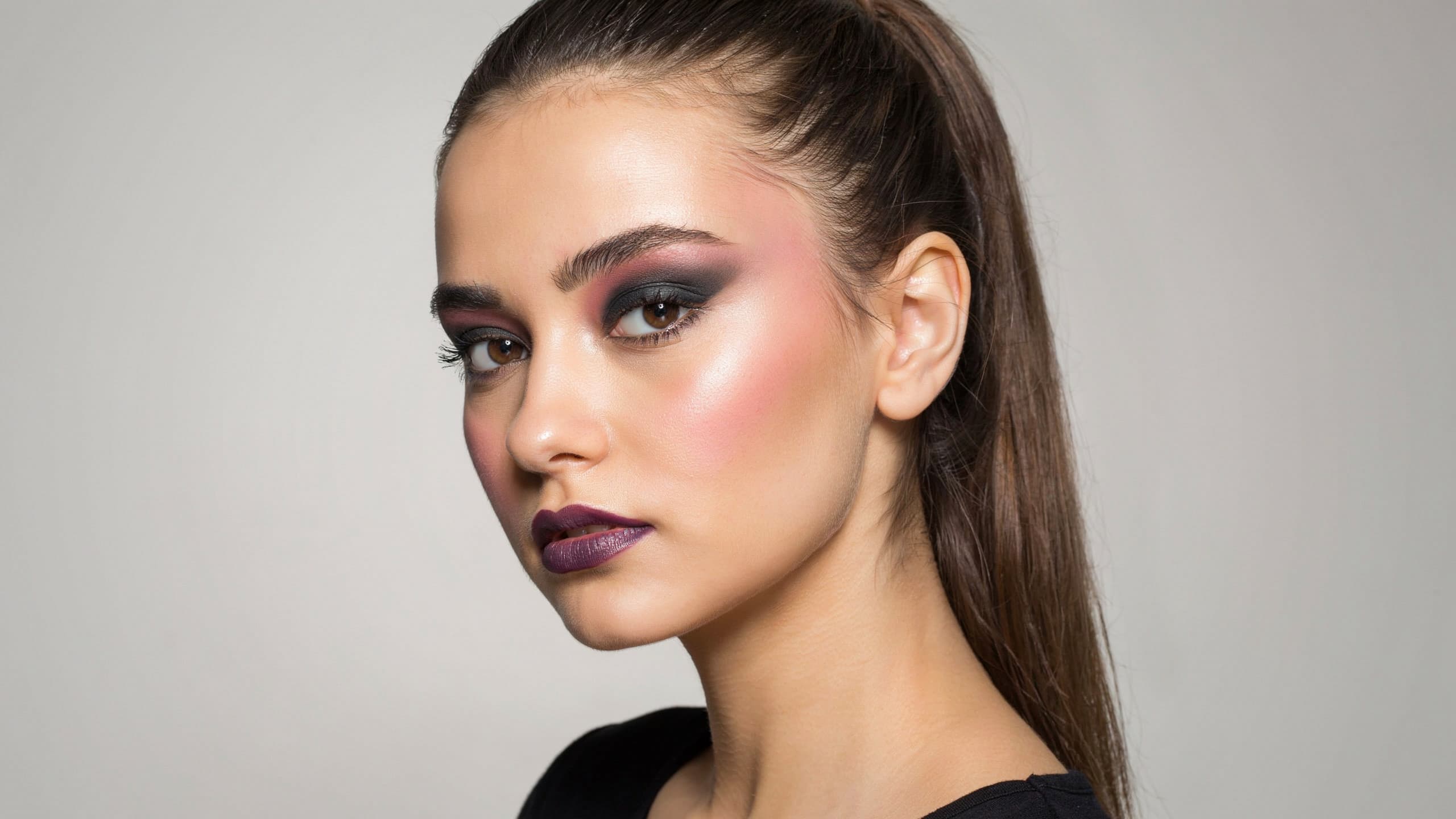 A girl with a high pony tail, and dark egirl make up on