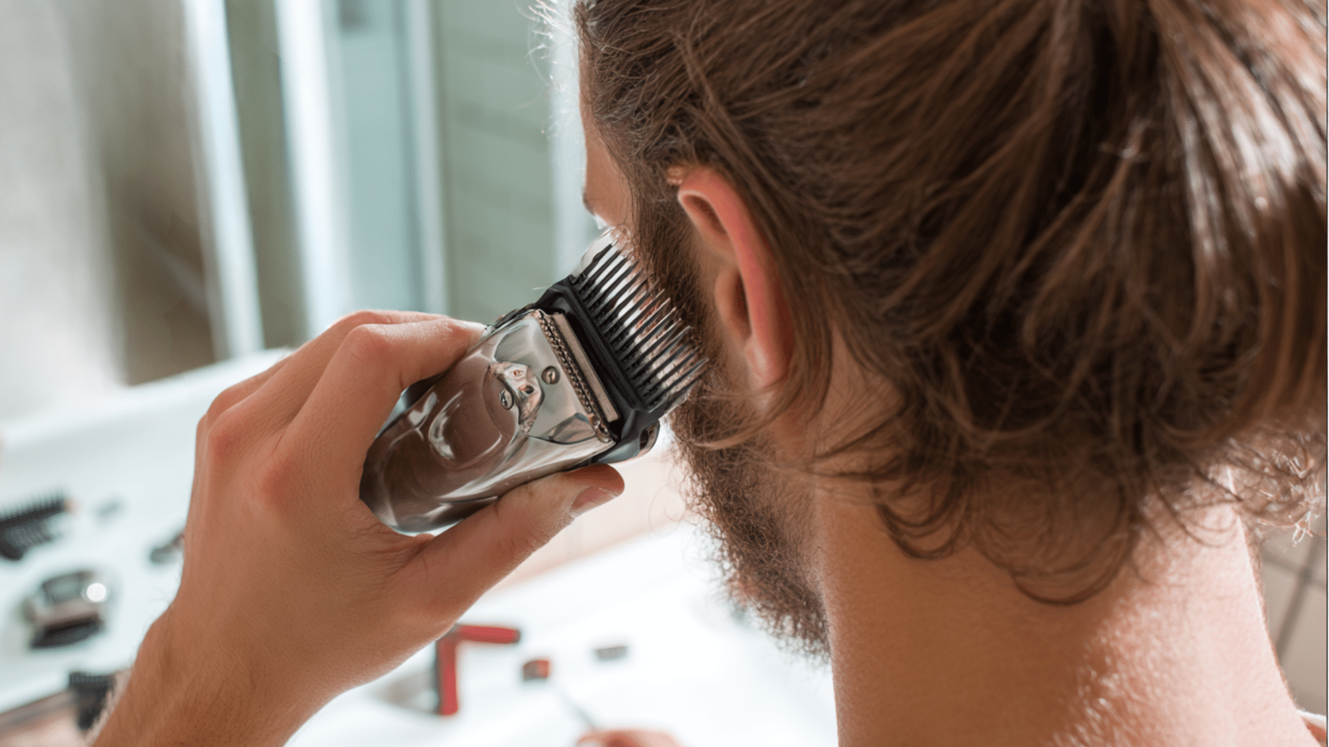 Clipper with guard to trim men’s hair at home, demonstrating DIY haircut tips for even blending and safe clipper use.