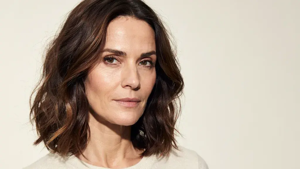 Medium length dark brown wavy hair with subtle highlights styled in a soft layered bob with natural texture and volume