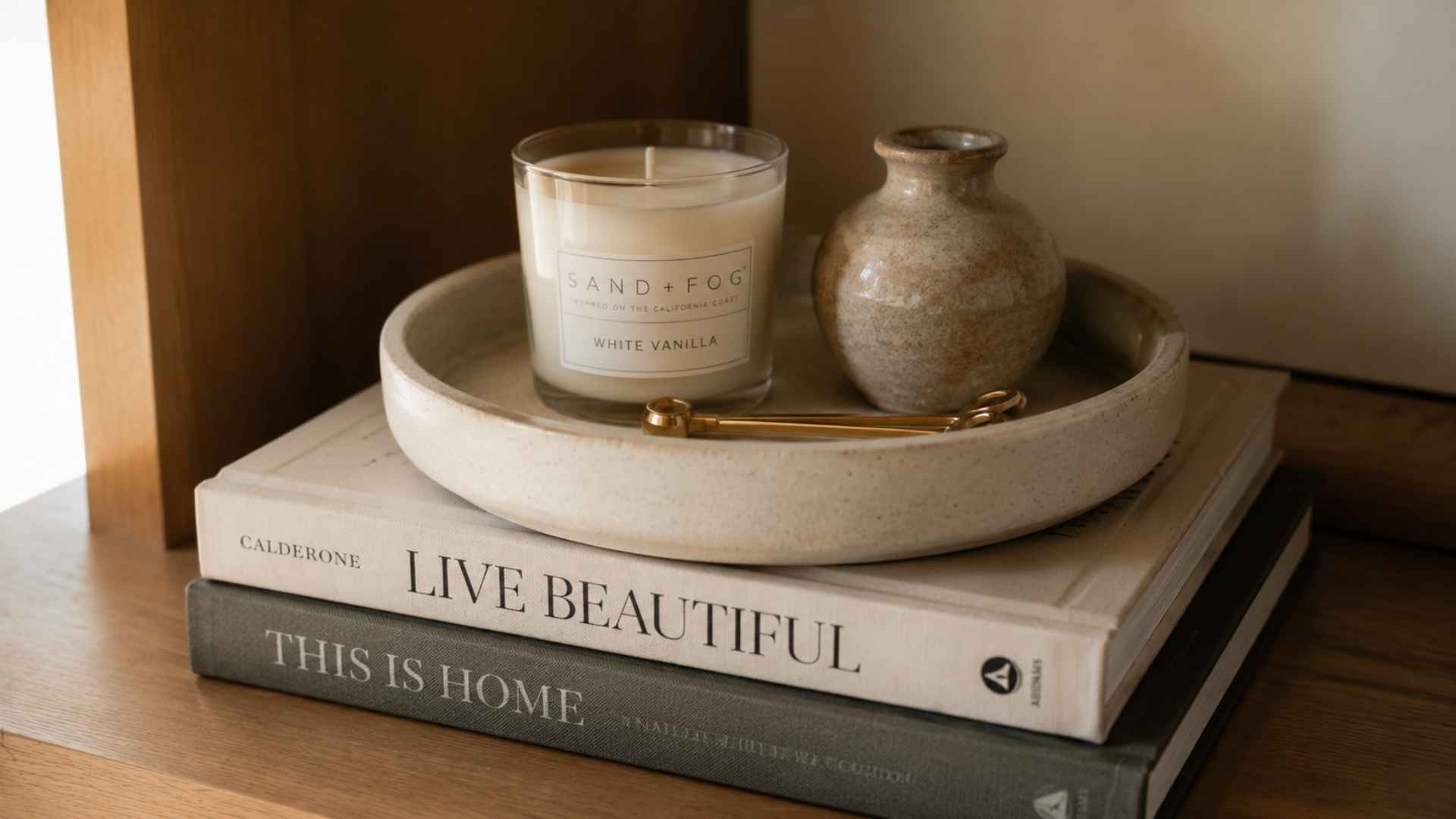 Stacked books topped with a tray and candle for a layered look