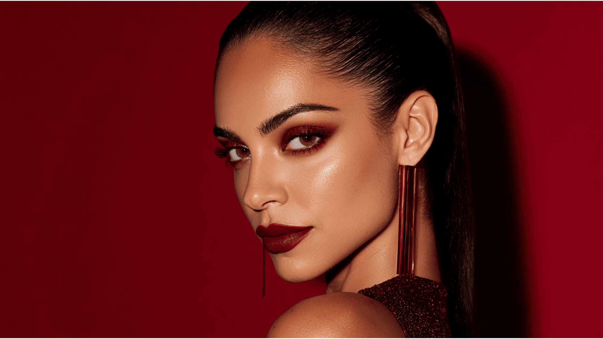 Full glam makeup featuring bold red lips, dramatic eyes, sculpted brows, and flawless radiant skin