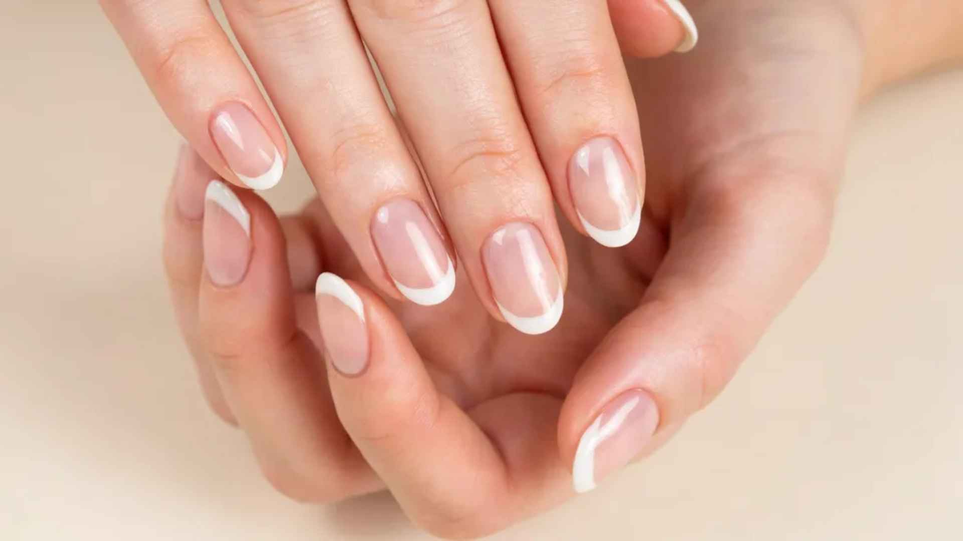 Glazed donut French tip nails with white tips and a glossy chrome overlay creating a modern pearly manicure look