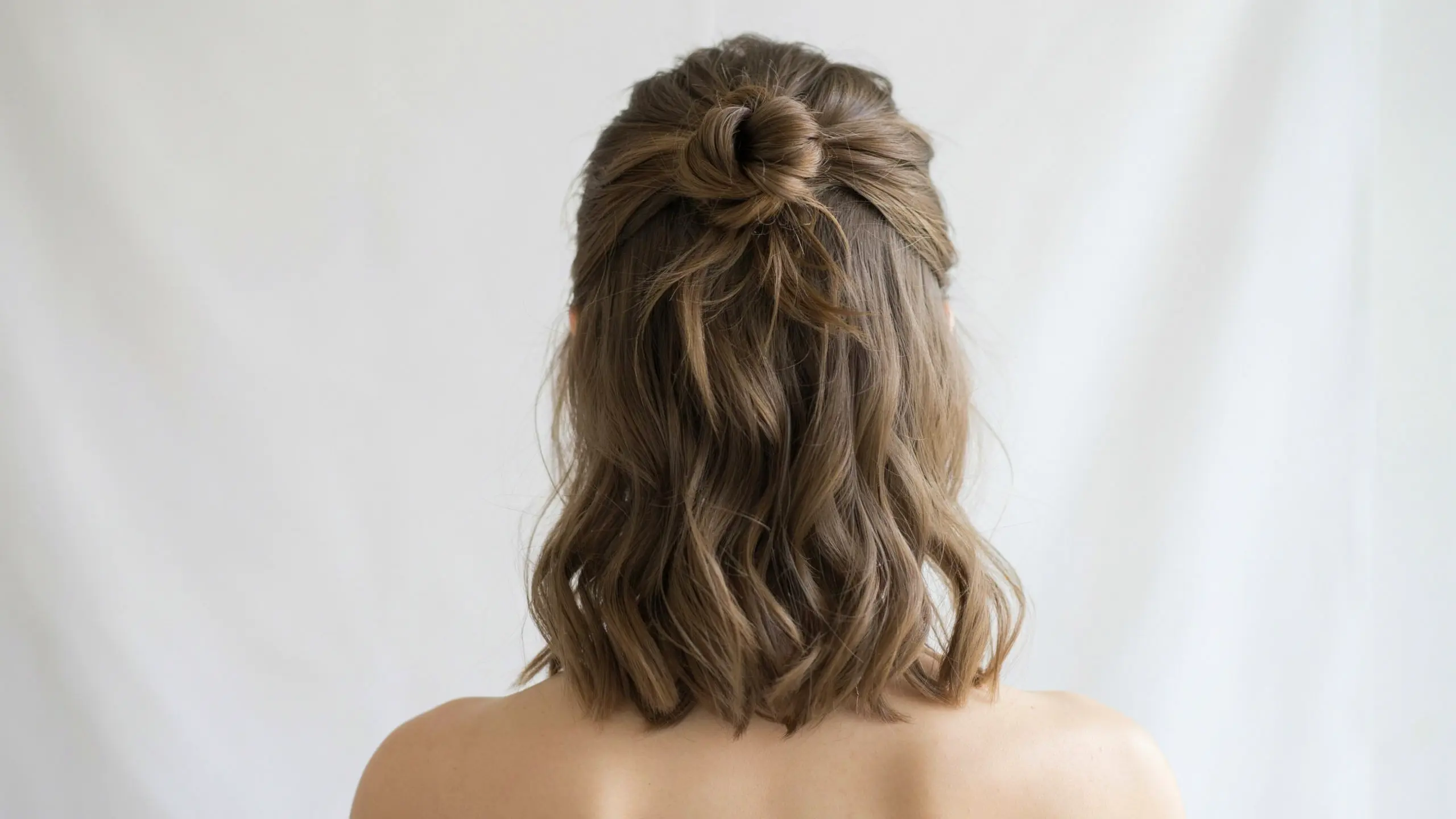Half up half down bun styled among cute updo hairstyles