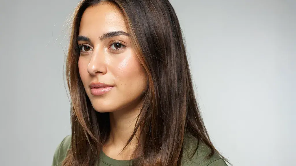Dark brown hair with subtle caramel highlights styled in a sleek straight layered cut with smooth texture and natural shine