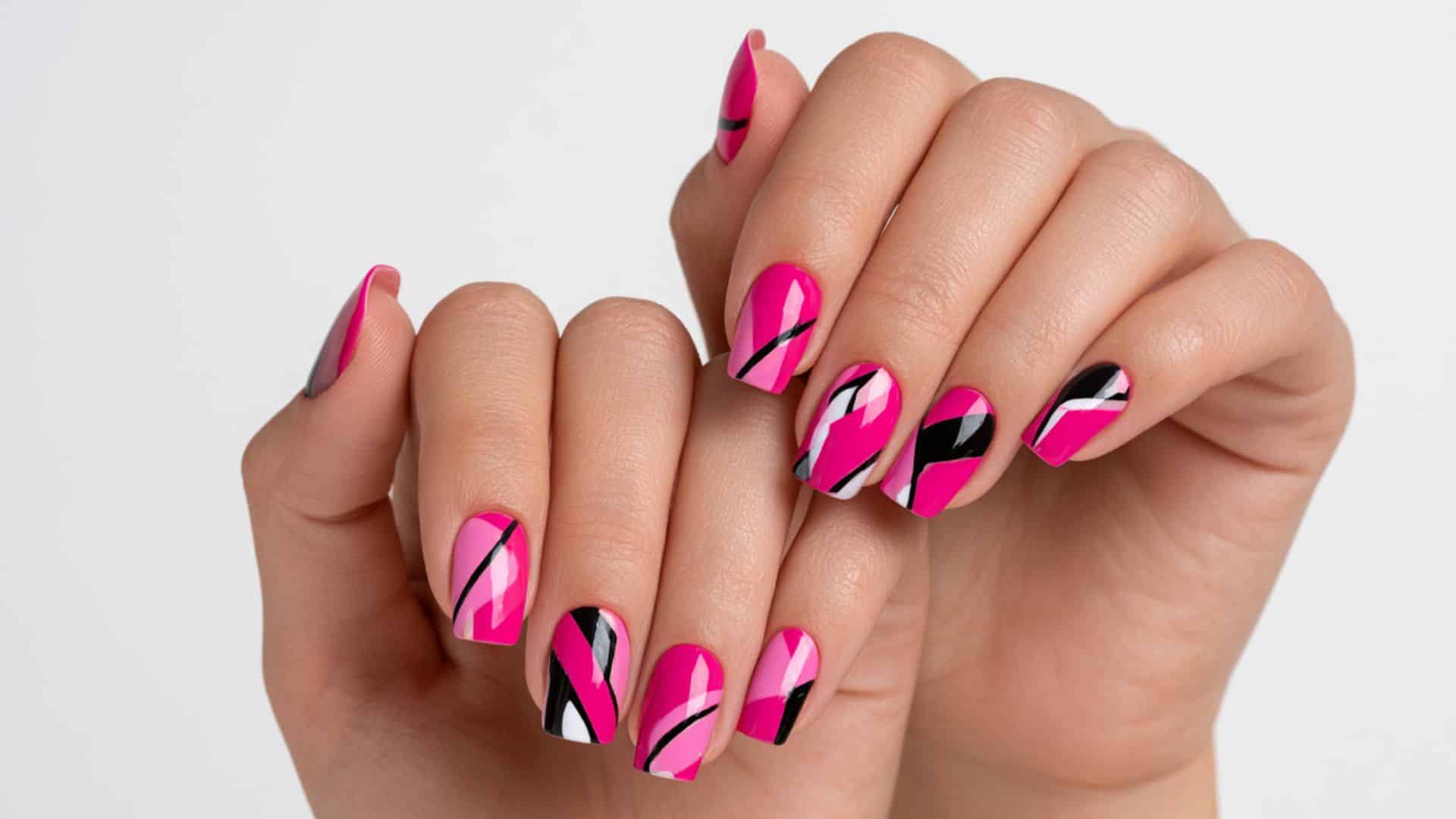 Bold pink manicure with black, white, and gray abstract geometric line art.