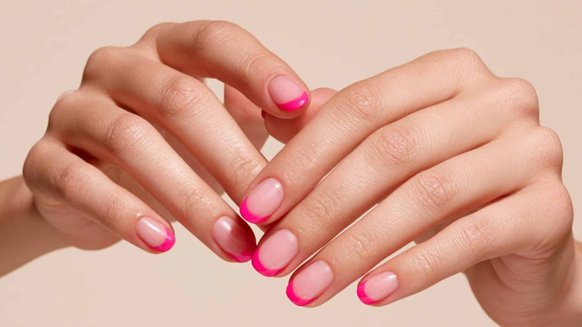 Classic nude nails with a fine hot pink French tip outline
