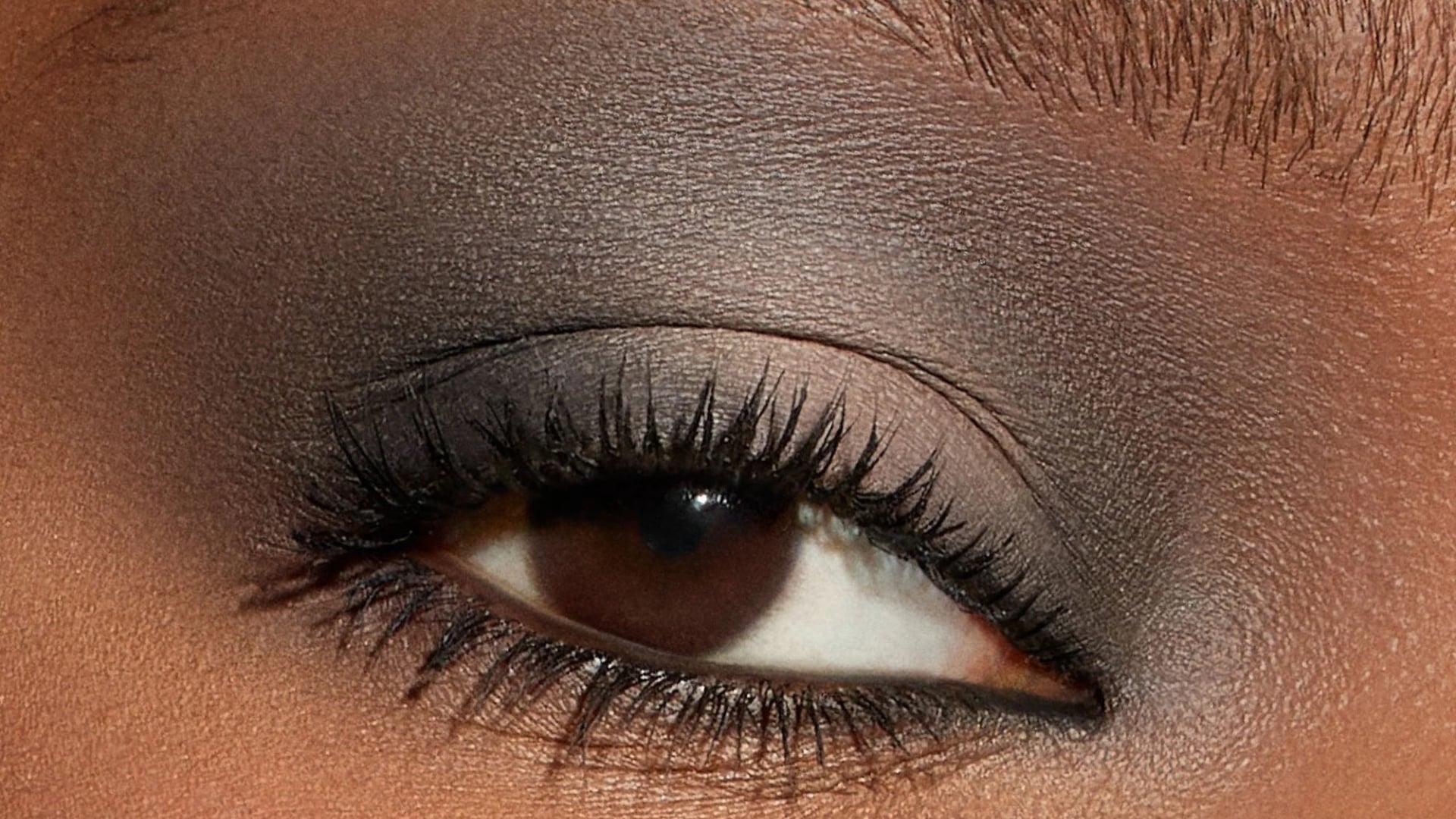 Woman wearing matte charcoal eyeshadow with soft blending for a clean and modern smoky inspired look.