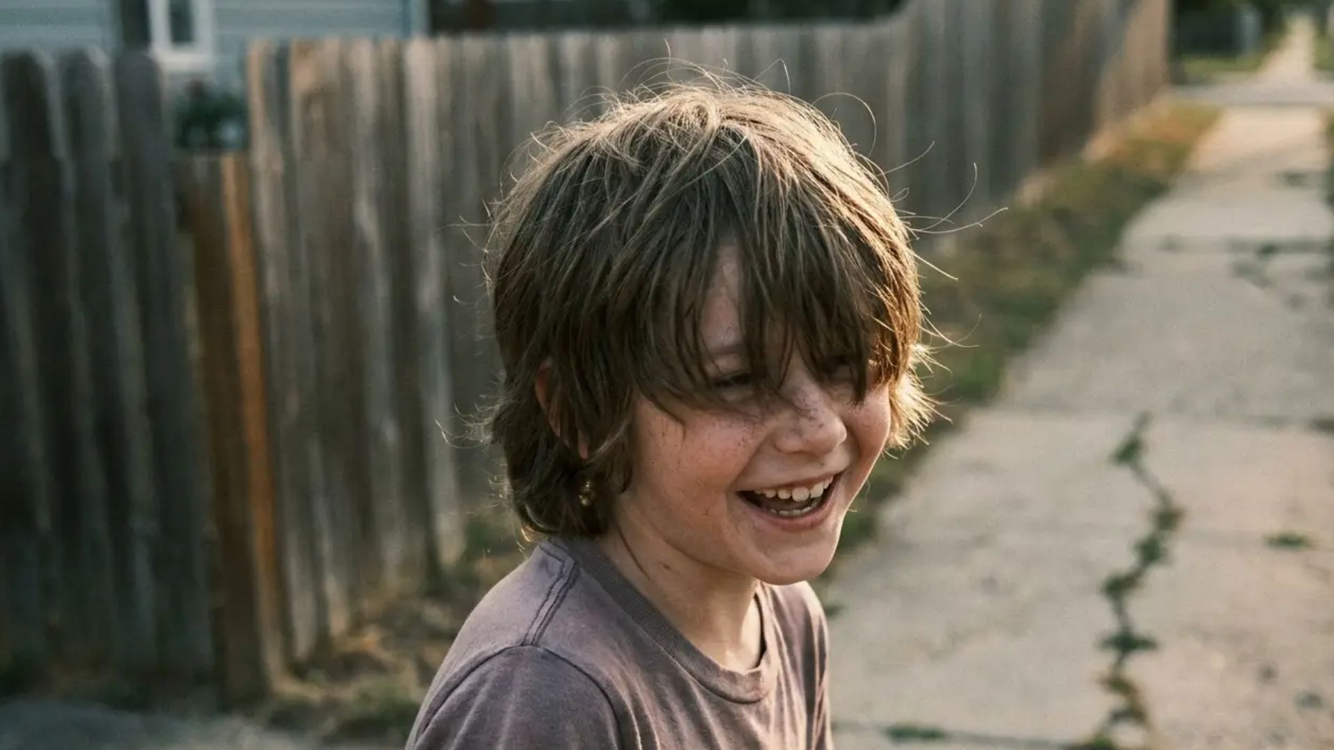 Boy with medium shag haircut featuring layered flow and natural volume in a casual outdoor street setting.