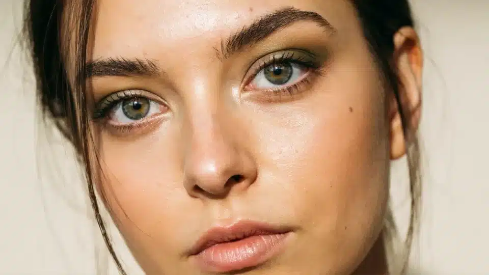 Woman wearing olive green eyeshadow with soft blending and natural makeup for an earthy eye look.