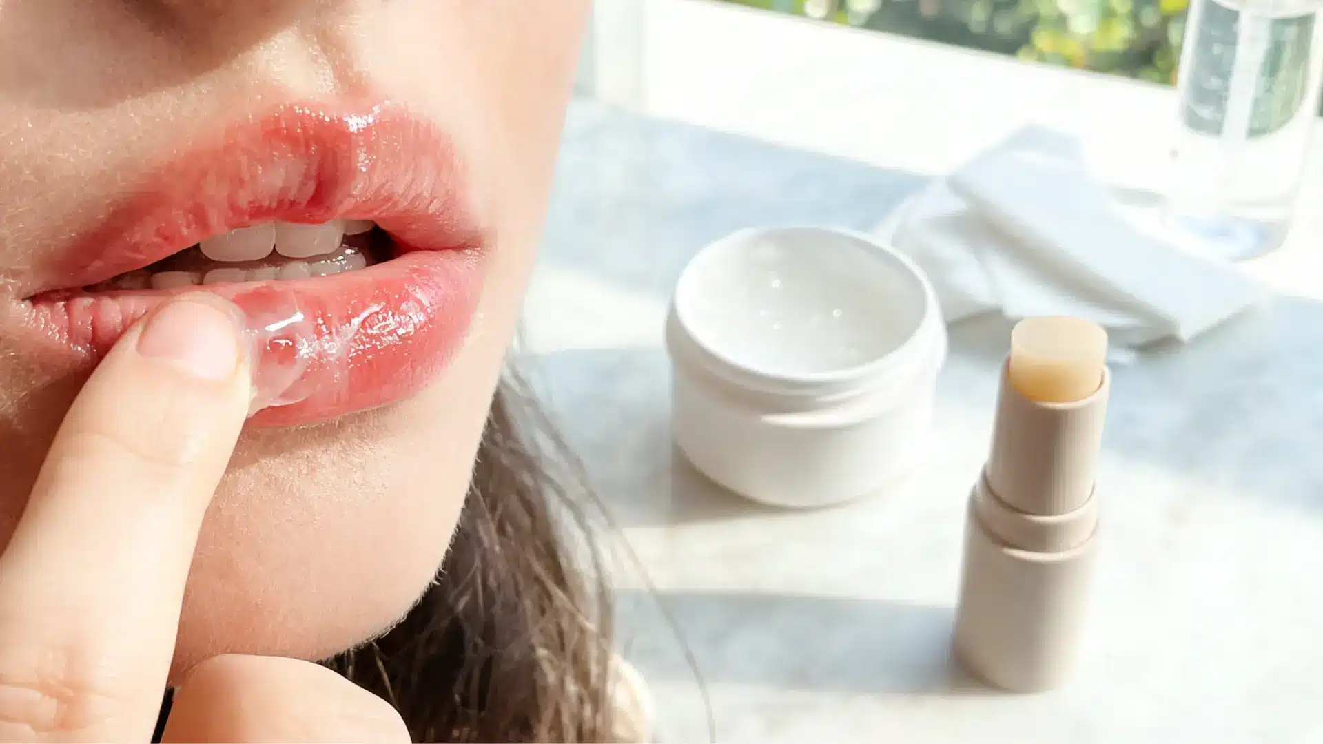 applying lip balm to sunburned lips