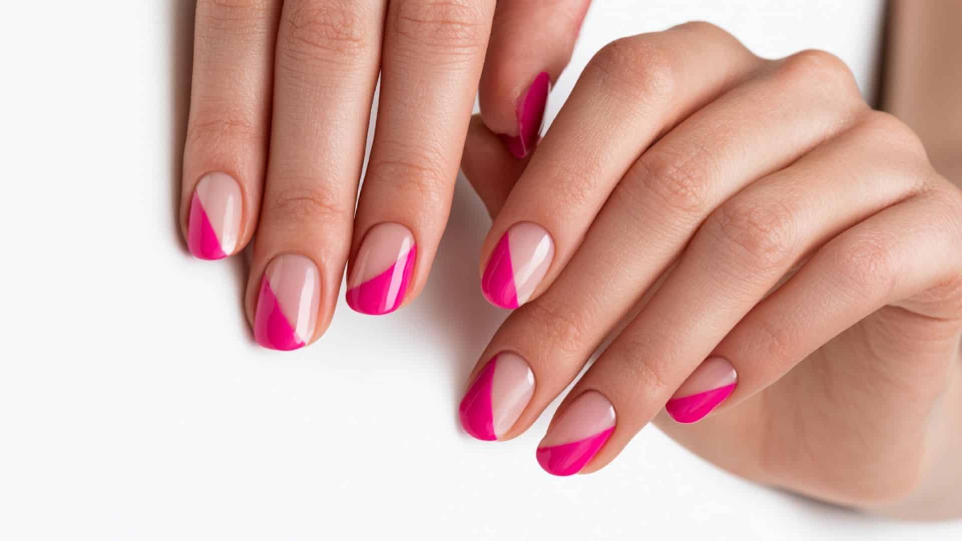 Nude nails with a diagonal hot pink negative space French tip design.