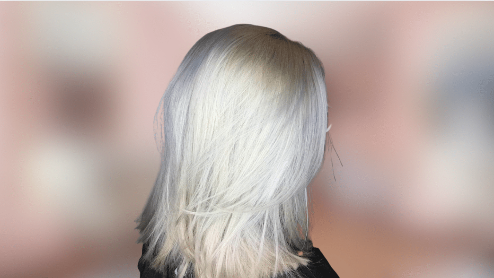 Wavy shoulder length hairstyle with striking platinum blonde color and icy finish