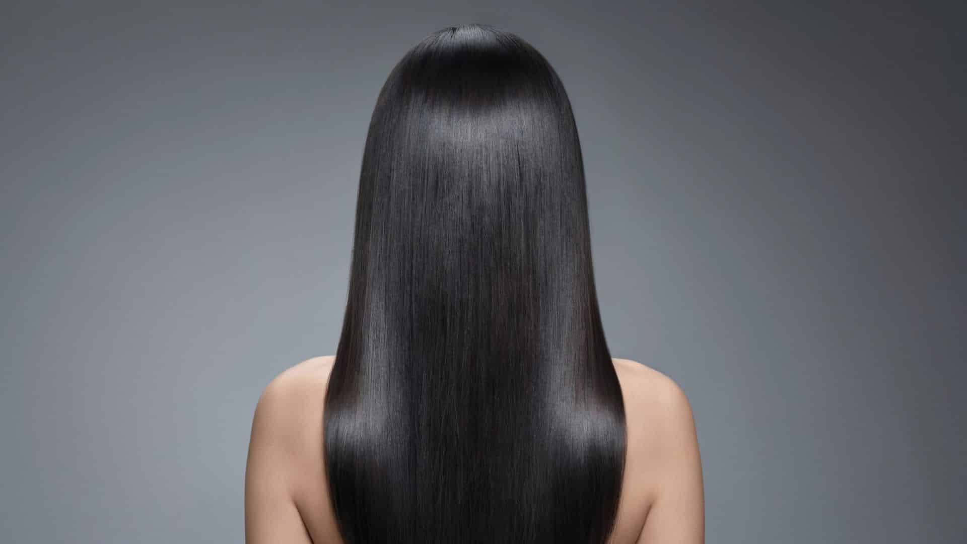 Sleek Y2K hairstyle with pin-straight hair and a precise middle part.
