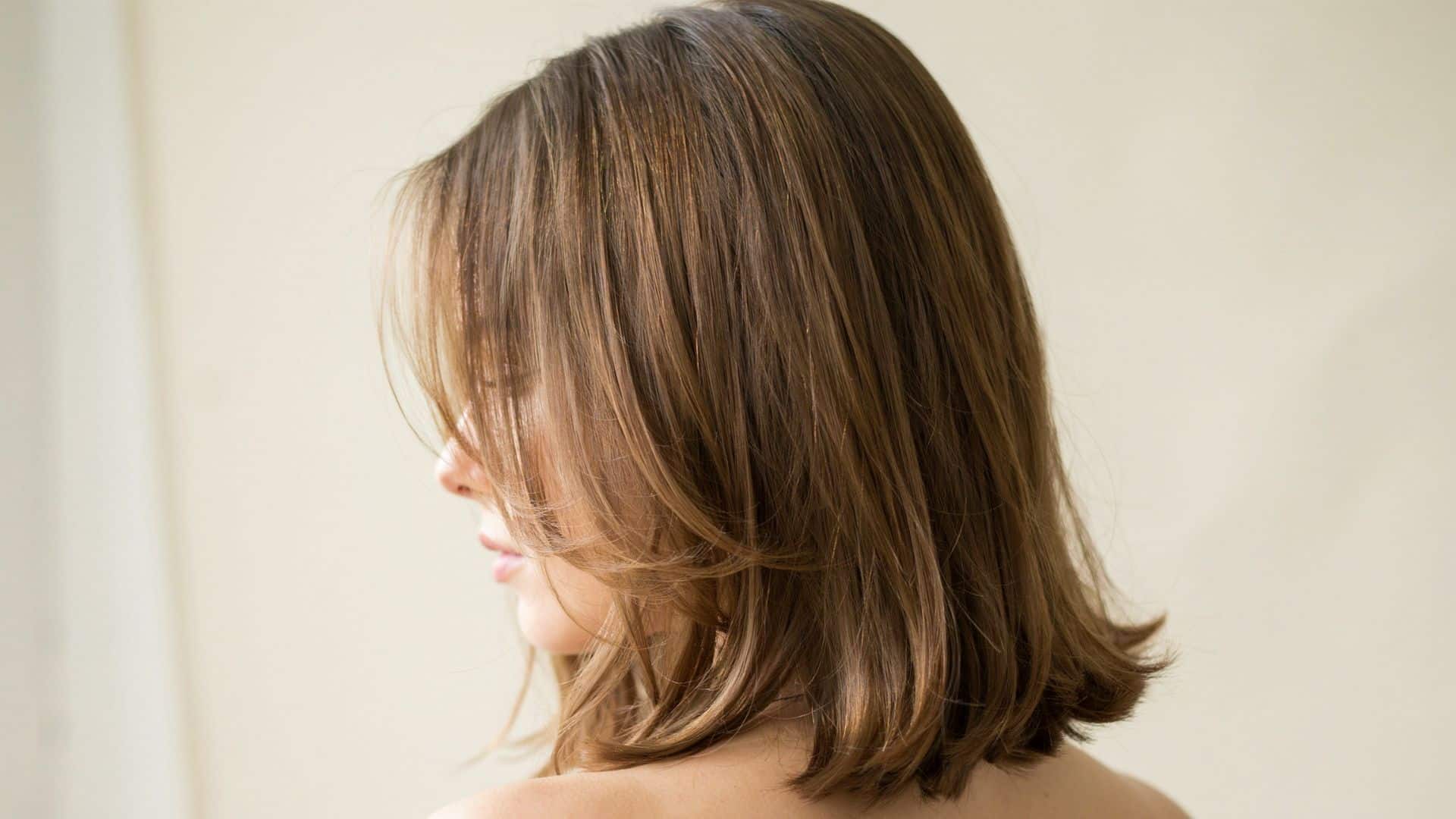 Y2K hairstyle with long side-swept bangs and smooth layered hair.