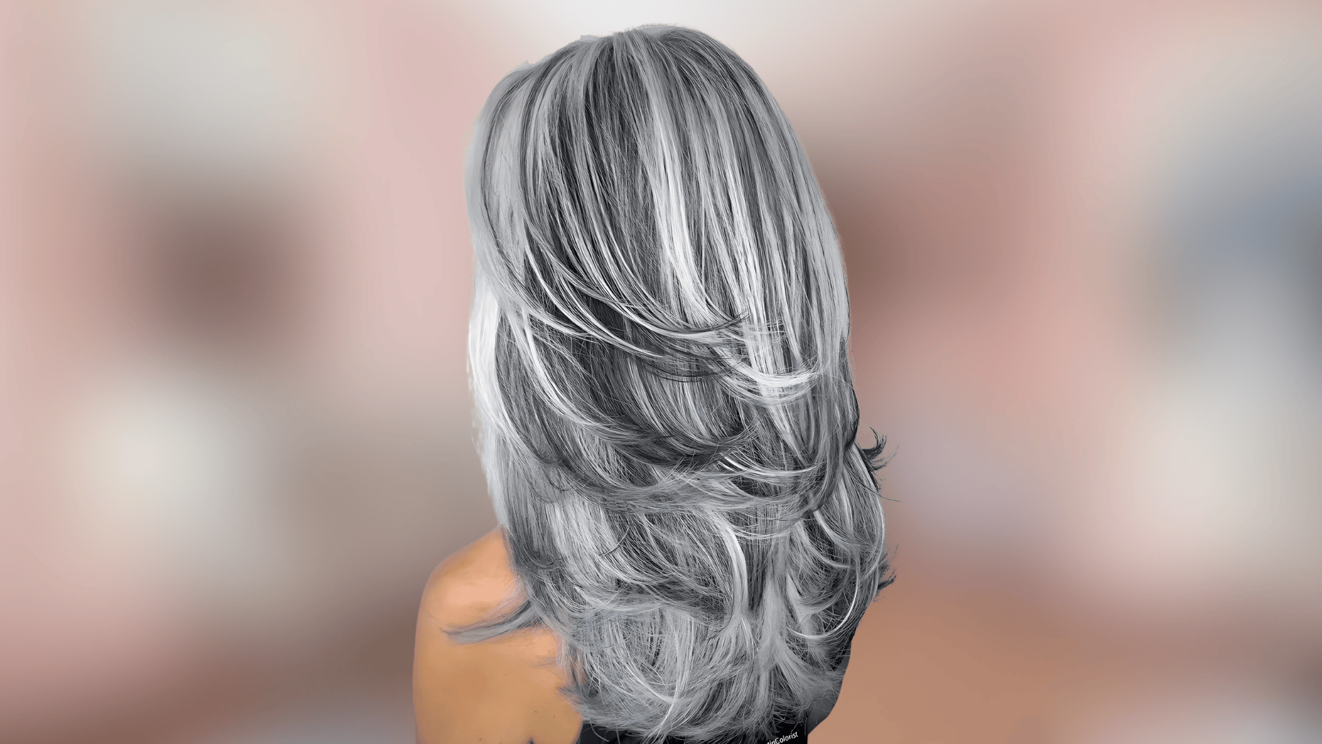 Shoulder length waves displaying silver grey hair color with cool metallic undertones