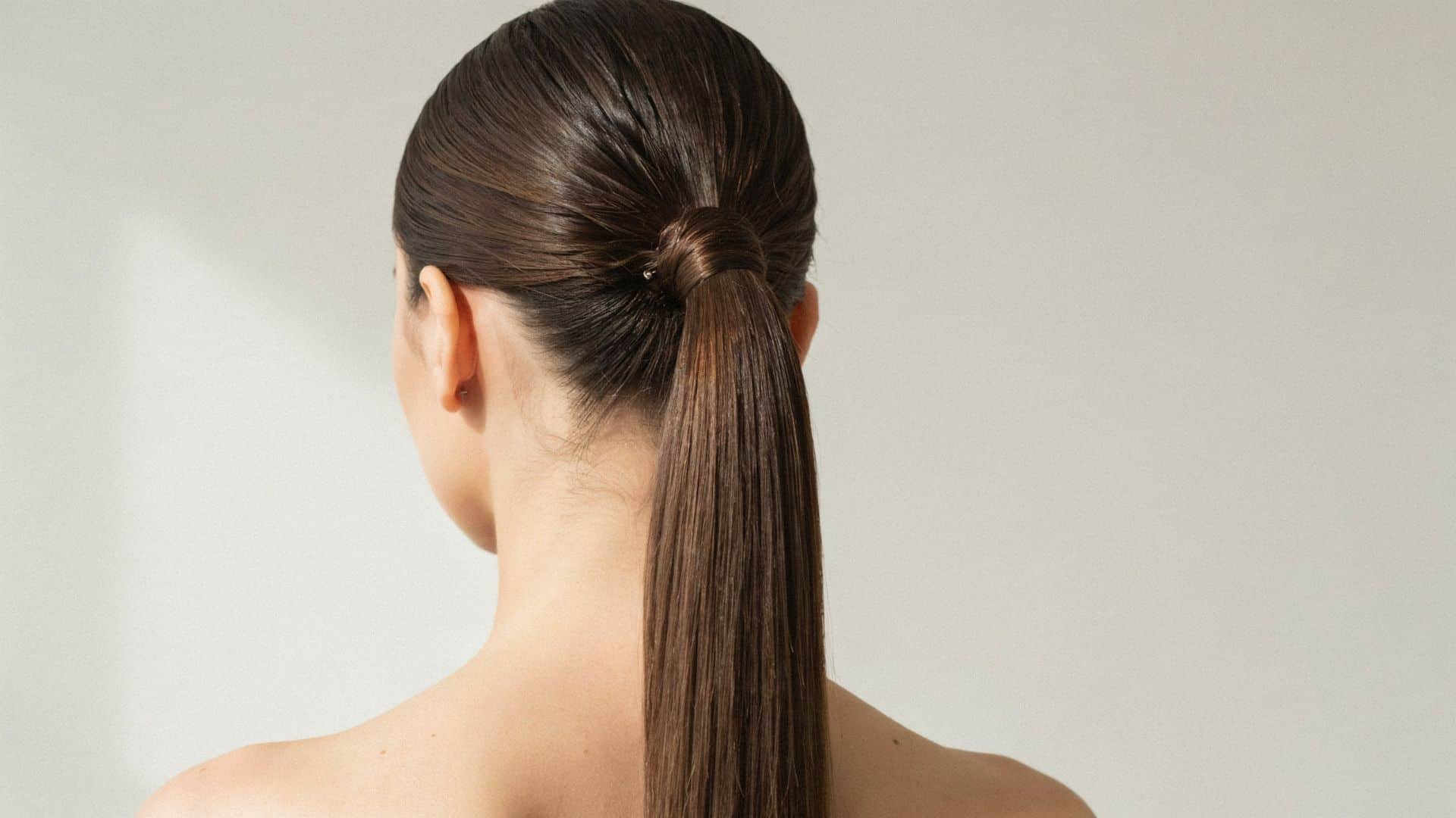Sleek Y2K high ponytail with smooth straight hair and a wrapped base detail.