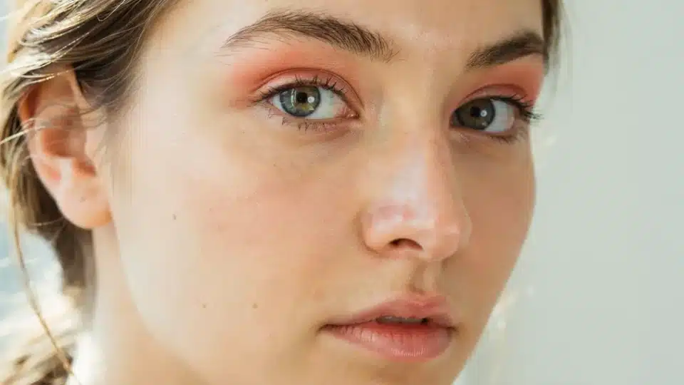 Woman wearing soft peach eyeshadow with natural makeup and a fresh radiant daytime appearance.