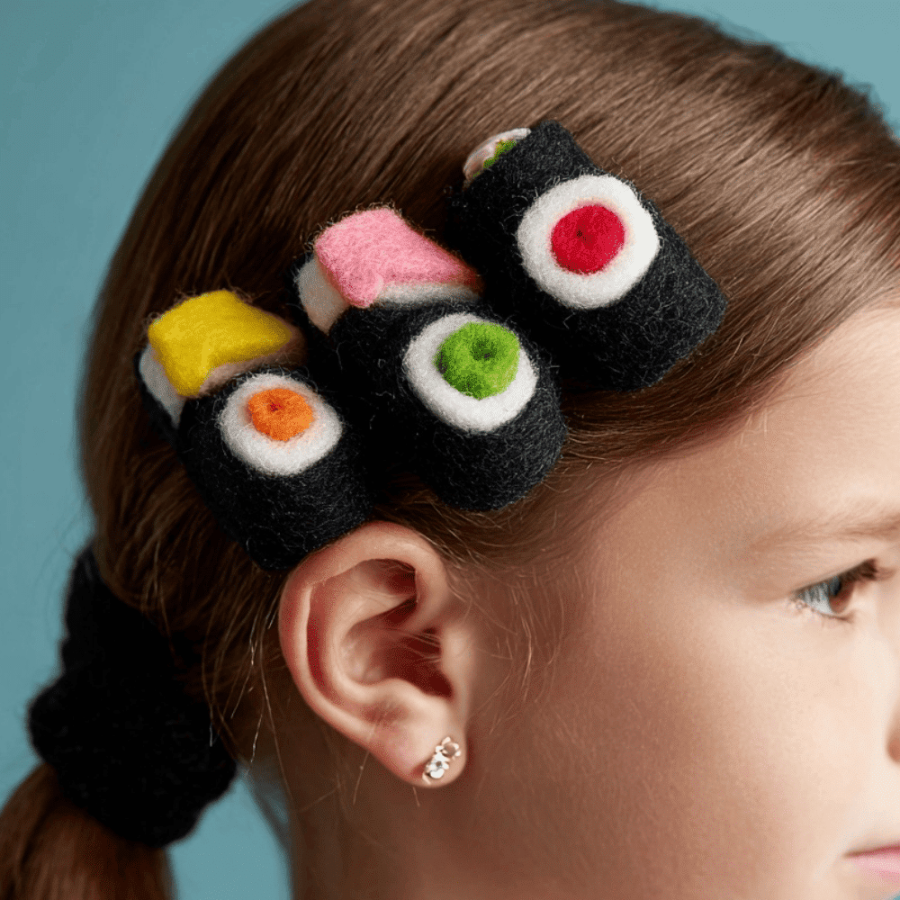 Hair decorated with colorful felt sushi roll bows for a creative food inspired look.