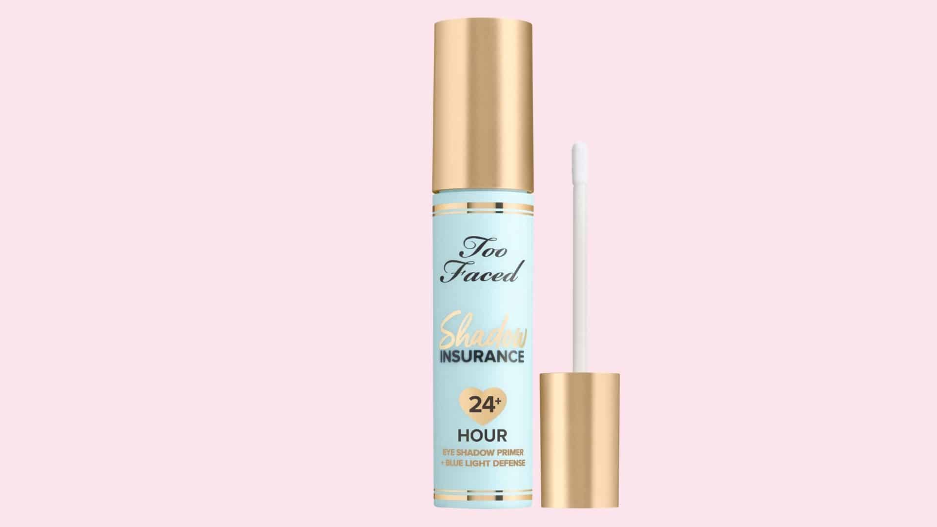 Too Faced Shadow Insurance eyeshadow primer tube with applicator on a pastel pink background