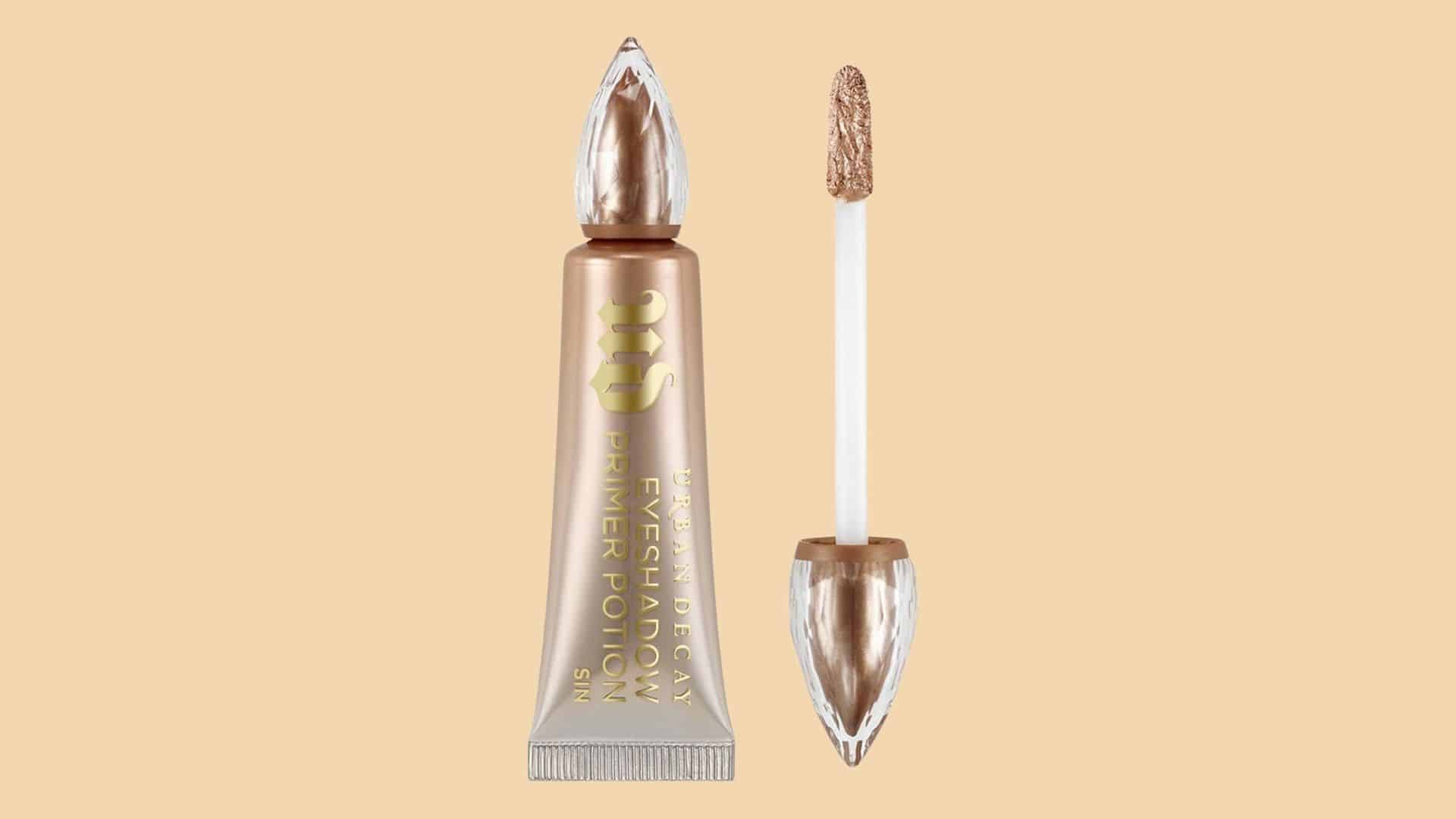 Urban Decay Eyeshadow Primer Potion tube and applicator displayed on a beige background