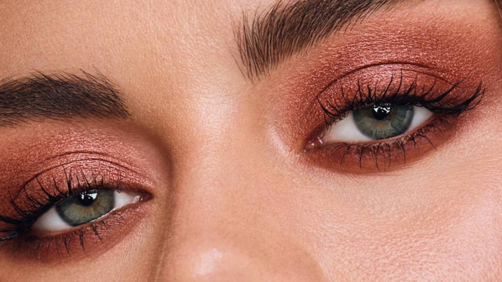 Woman wearing soft taupe eyeshadow with natural makeup for a simple everyday eye look.