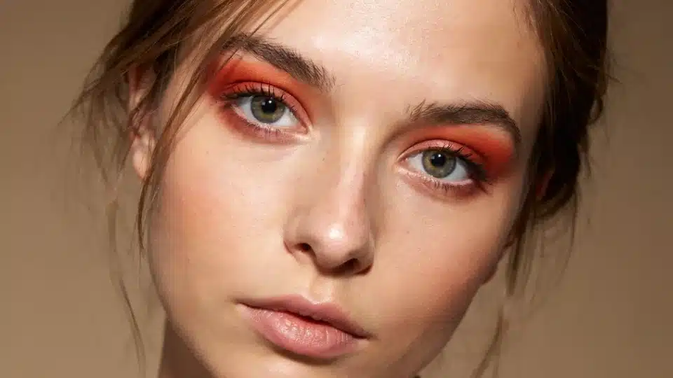 Woman wearing vibrant copper red eyeshadow blended softly for a warm glowing everyday makeup look.