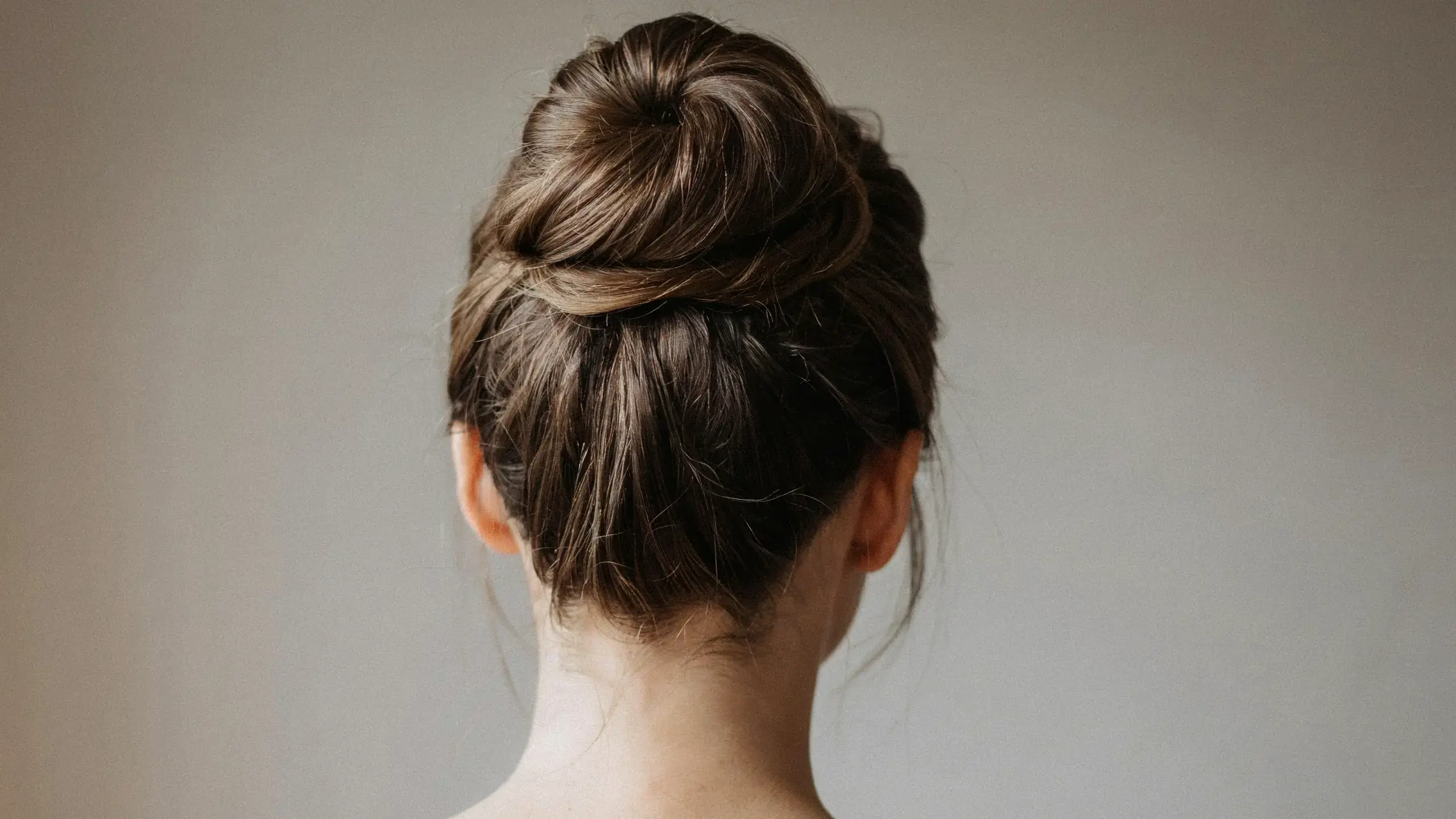 Voluminous updo hairstyles styled into a soft, textured high bun