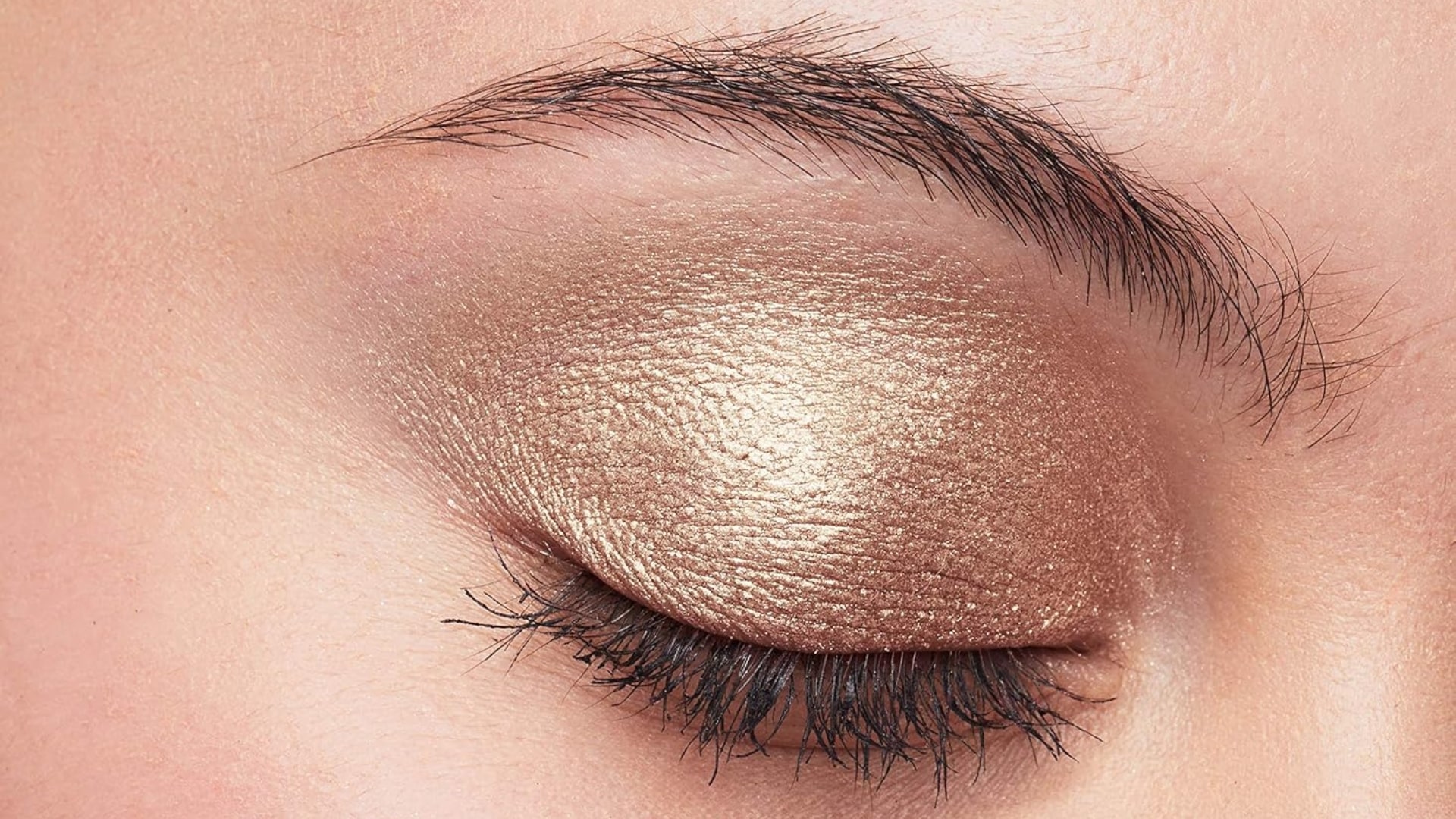 Woman wearing warm copper eyeshadow with a soft everyday makeup look highlighting warm metallic tones on the eyelids.