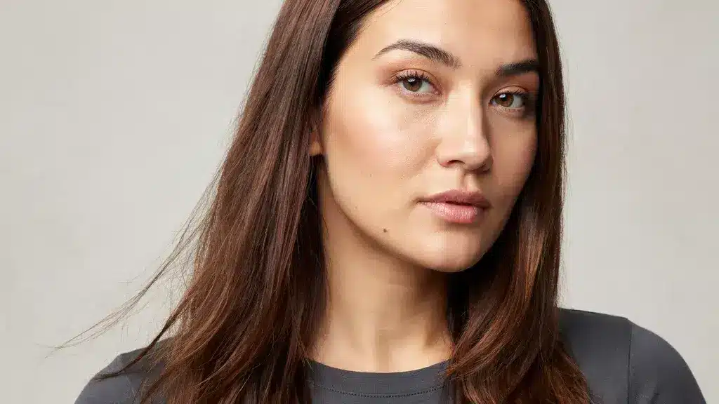 Long straight brown hair with subtle warm highlights styled in a sleek layered cut with smooth texture and natural shine