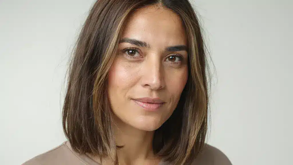 Medium brown hair with blonde face framing highlights styled in a sleek shoulder length bob with smooth layered texture and shine