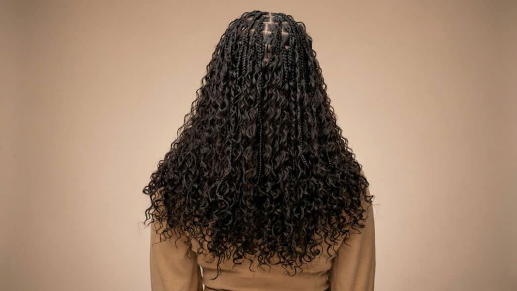 Back view of boho braids with knotless sections and loose curly strands for an effortless look