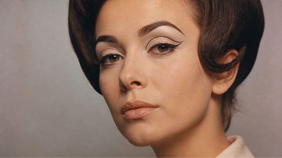 Classic 60s makeup featuring a sharp mod cut crease, black eyeliner, dramatic lashes, and nude lips