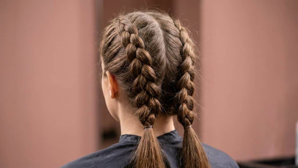 Back view of a raised Dutch braid hairstyle showing the three dimensional underhand weaving pattern